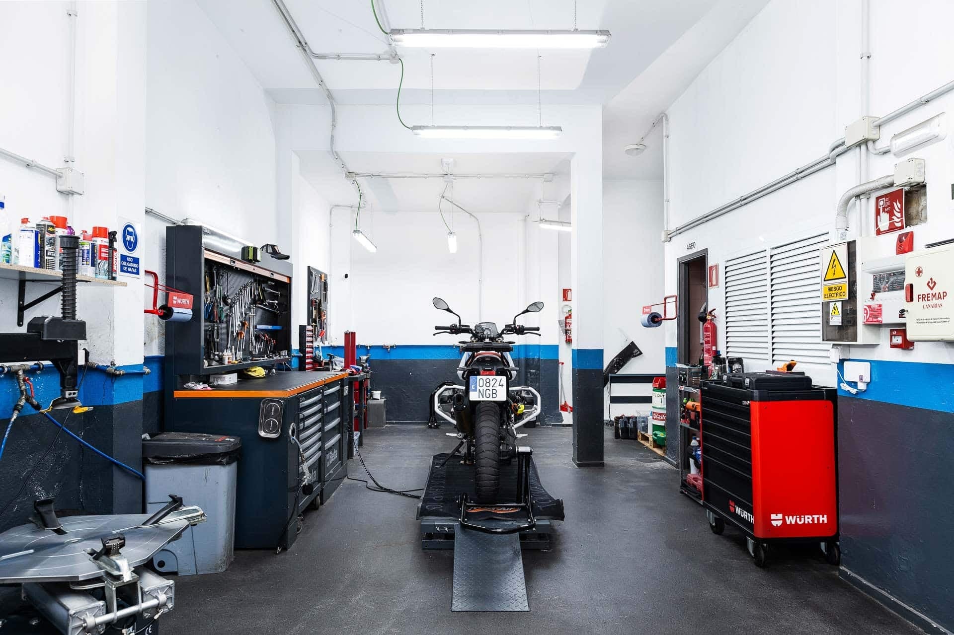 Mechanic servicing a motorcycle in the Canary Ride workshop